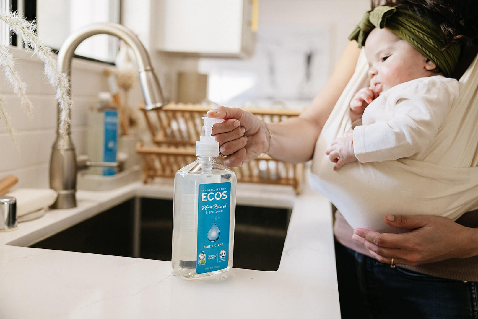 Woman holding baby using ECOS hand soap
